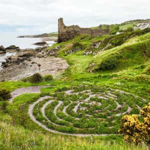 Dunure Labyrinth from above with the castle ruins and sea in the background.